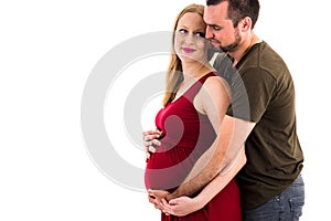 Young pregnant couple in love expecting child, studio portrait