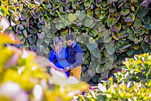 Young pregnant couple standing in the park