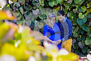 Young pregnant couple standing in the park