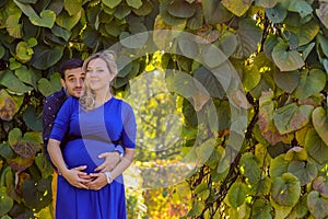 Young pregnant couple standing in the park