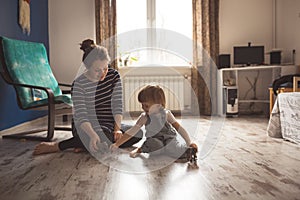 Young pregnant mother and son playing on floor, lifestyle,