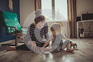 Young pregnant mother and son playing on floor, lifestyle,