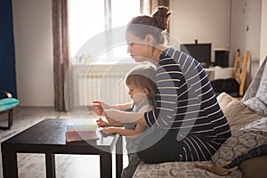 Young pregnant mother and son reading a book, lifestyle,