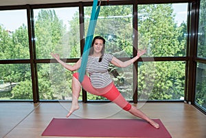 Young pregnant woman aerial yoga exercises indoor fly yoga