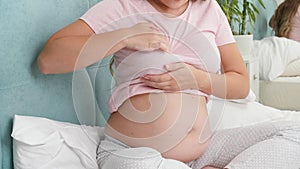 Young pregnant woman with big belly checking and touching her breast before lactation. Concept of pregnancy healthcare