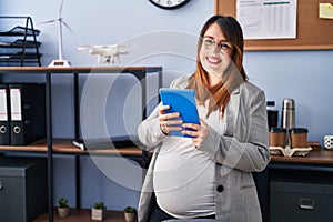 Young pregnant woman business worker using touchpad working at office