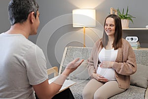 Young pregnant woman in consultation with professional psychologist listens to advice on improving behavior in life developing