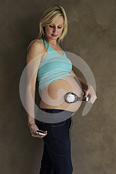 Young pregnant woman dancing to music with her unborn child