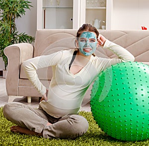 Young pregnant woman doing exercises at home
