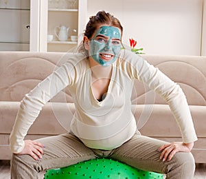 Young pregnant woman doing exercises at home