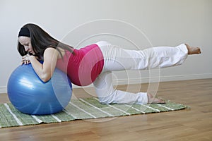 Young pregnant woman doing leg muscle exercise