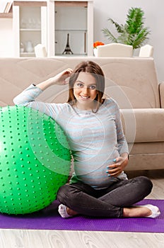 The young pregnant woman doing sport exercises at home