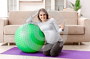 The young pregnant woman doing sport exercises at home