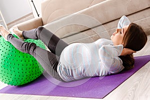 The young pregnant woman doing sport exercises at home