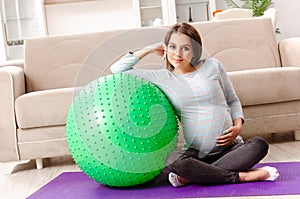 The young pregnant woman doing sport exercises at home