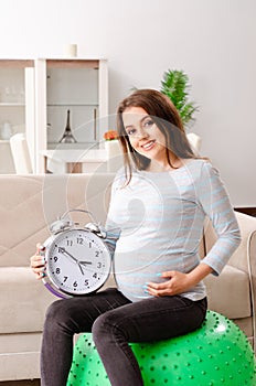 The young pregnant woman doing sport exercises at home