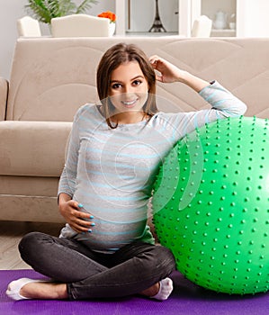 The young pregnant woman doing sport exercises at home