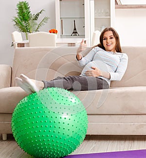 The young pregnant woman doing sport exercises at home