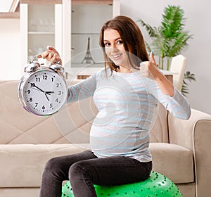 Young pregnant woman doing sport exercises at home