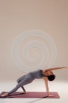 Young pregnant woman doing yoga exercises and meditating at studio. Health care, mindfulness and wellness concept