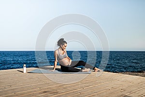 Young pregnant woman doing yoga outdoor - Sport exercises and maternity concept for healthy lifestyle - Focus on face