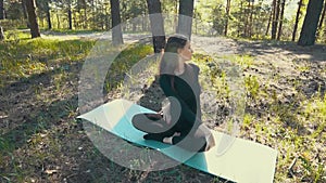 Young pregnant woman doing yoga outside.