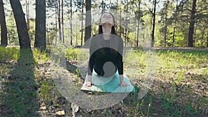 Young pregnant woman doing yoga outside.