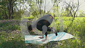 Young pregnant woman doing yoga outside.