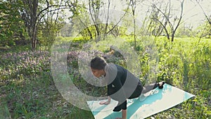 Young pregnant woman doing yoga outside.