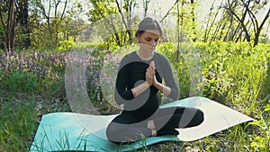 Young pregnant woman doing yoga outside.