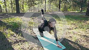 Young pregnant woman doing yoga outside.