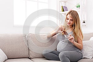 Young pregnant woman eating chocolate bar