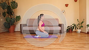 A young pregnant woman is engaged in fitness at home. Exercises for pregnant women.