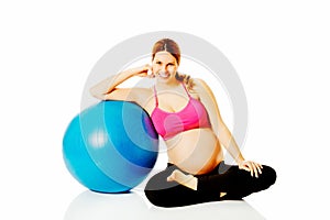 Young pregnant woman excercises with gymnastic ball