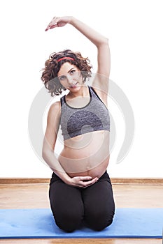 Young pregnant woman exercises on the mat