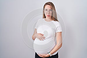 Young pregnant woman expecting a baby, touching pregnant belly depressed and worry for distress, crying angry and afraid