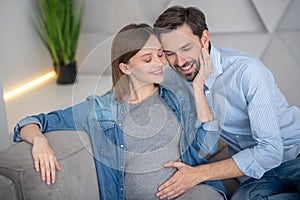 Young pregnant woman feeling happy with her husband