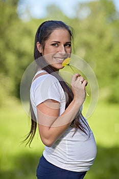 Young pregnant woman with flower.