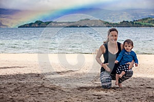 Young pregnant woman having fun with her baby girl at the beautiful white beach of Lake Tota located in the department of Boyaca