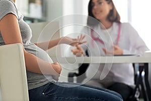 Young pregnant woman with her doctor in clinic