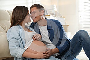 Young pregnant woman with her husband at home