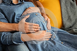 Young pregnant woman with her husband at home, closeup