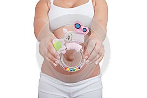 Young pregnant woman hold in hand baby rattle