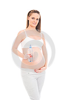 A young pregnant woman holding a bottle of fresh water