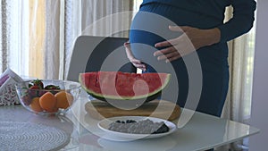 Young pregnant woman holding her belly