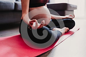 young pregnant woman at home practicing yoga sport. healthy lifestyle
