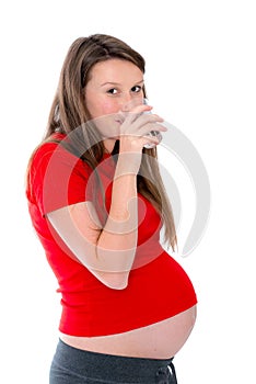 Young pregnant woman isdrinking water