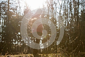 Young pregnant woman in last trimester standing in autumn forest