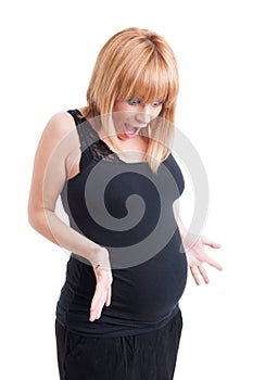 Young pregnant woman looking excited at her big belly