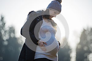 Young pregnant woman looking at her belly lovingly photo